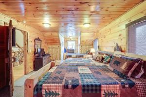 Cette cabane en rondins comprend un lit et une télévision. dans l'établissement Pet-Friendly Butler Cabin with Hot Tub, Walk to Lake, à Butler