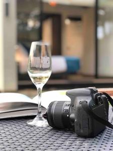 un bicchiere di vino e una macchina fotografica su un tavolo di Luxury Glamping - Tiny House al natural a La Vega