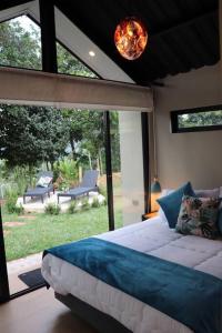 a bedroom with a bed and a view of a yard at Luxury Glamping - Tiny House al natural in La Vega