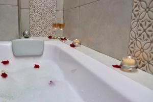 a white bath tub with candles and red flowers in it at Luxury Glamping - Tiny House al natural in La Vega