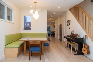a dining room with a green bench and a piano at Bright 3 bedroom house Downtown in Toronto