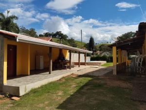 a yellow house with a patio in the yard at Chácara Portal dos Anjos in Cunha
