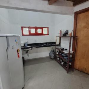 uma cozinha com um frigorífico, um lavatório e uma janela em Vila das Acácias em Vale do Capao