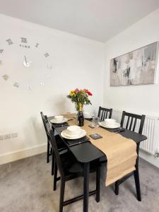 a dining room table with chairs and a clock on the wall at The Yorkshire Hosts - The Water Mill in Haworth