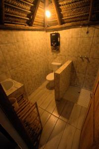 a bathroom with a toilet and a tub and a sink at Vista Do Deus Resort in Ligogo