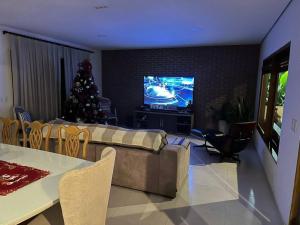 Sala de estar con árbol de Navidad y TV en Sítio aconchegante em Mulungu, en Mulungu