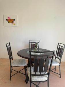 a dining room table with two chairs and a butterfly picture at Casa bugambilias in Cabo San Lucas