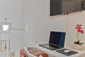 a laptop computer sitting on a desk with a chair at Charmant duplex à deux pas de Paris et du RER B - parking gratuit in Gentilly