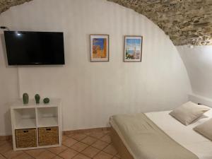 Un dormitorio con una cama y un televisor de pantalla plana. en Studio Perle de Menton, en Menton