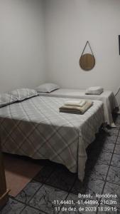 Una cama con una manta y una lámpara. en Apartamentos aconchegantes no centro da cidade en Cacoal