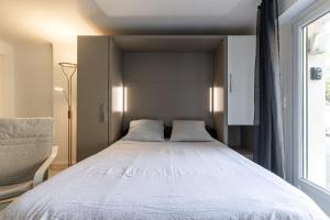 - une chambre avec un grand lit et une fenêtre dans l'établissement Studio avec parking à 12mns du centre historique de bayonne, à Bayonne
