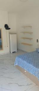 um quarto com uma cama e um frigorífico em Suítes com piscina Praia do Forte Tomas na Praia do Forte