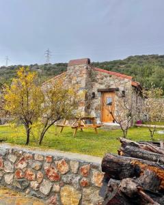 ein Steingebäude mit einer Holztür auf einem Feld in der Unterkunft Karaincirevleri Müstakil Taş Ev in Emecik
