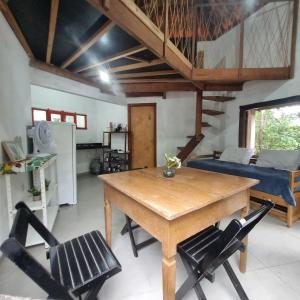 uma sala de estar com uma mesa de madeira e cadeiras em Vila das Acácias em Vale do Capao