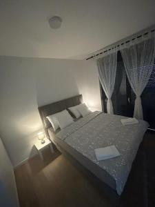a bedroom with a large bed and a window at MM Apartments Zore in Zagreb