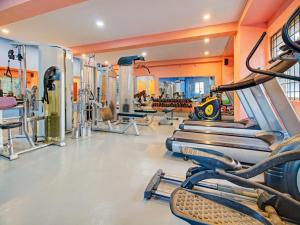 a gym with rows of treadmills and machines at Super OYO RK Club House in Kammasandra