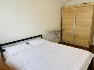 ein Schlafzimmer mit einem großen weißen Bett und einem Schrank in der Unterkunft Spacious apartment next to Royall Mall on B Street in Pristina