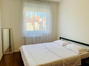 Schlafzimmer mit einem großen Bett und einem Fenster in der Unterkunft Spacious apartment next to Royall Mall on B Street in Pristina