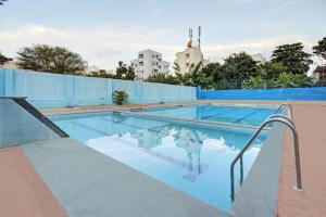 an empty swimming pool with a blue wall and a swimming pooliterator at Super OYO RK Club House in Kammasandra