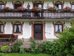 una casa antigua con flores en el balcón en Schusterbauer-Hof, en Schleching