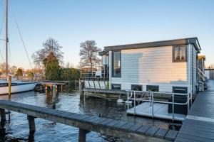 a tiny house on a dock on the water at Watervillashiraz in Aalsmeer