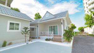 a house with a swimming pool in front of it at Baan Casita With Private Seaside Cottage in Hua Hin