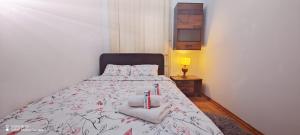 1 dormitorio con 1 cama con toallas y velas en Lux Apartment Rose 2 60m2, en Kragujevac