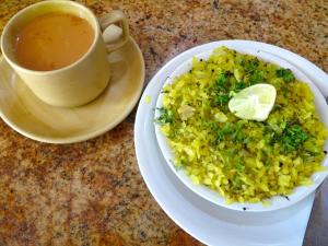 a plate of food with a bowl of rice and a cup of tea at Home Stay 1 in Noida