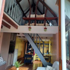 a loft bed in a living room with a staircase at LA PETITE GRANGE 