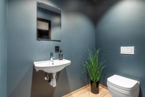 ein Badezimmer mit einem weißen Waschbecken und einer Toilette in der Unterkunft Toppleilighet på bryggen i Sogndal med fantastisk utsikt in Sogndal + 3 Fotos