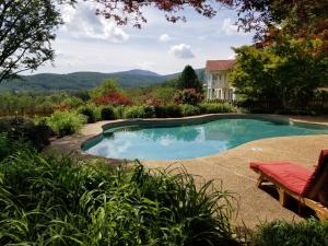 a swimming pool in the yard of a house at Fairhill Farm Country Vacation Rentals in Stanardsville