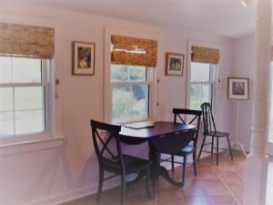 una sala da pranzo con tavolo, sedie e finestre di Fairhill Farm Country Vacation Rentals a Stanardsville