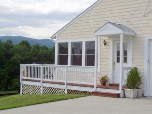 een wit huis met een veranda en een wit hek bij Fairhill Farm Country Vacation Rentals in Stanardsville