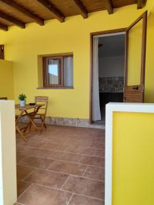 Zimmer mit einem Tisch und einer gelben Wand in der Unterkunft marco apartment in Lampedusa