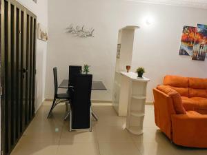 ein Wohnzimmer mit einem orangenen Sofa und einem Tisch in der Unterkunft Sylvadore'Appart in Cotonou
