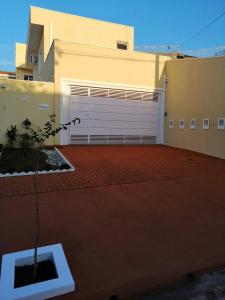 a garage with a white garage door on a house at Elegante Duplex Oceanico da Elena Super Cozinha USP y UfSCAR in São Carlos