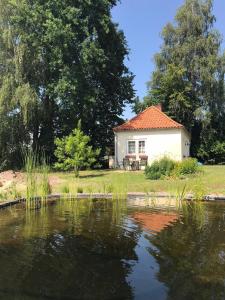 ein Haus mit einem Teich davor in der Unterkunft Kleines Ferienhaus im Grünen bei Lüneburg in Bardowick