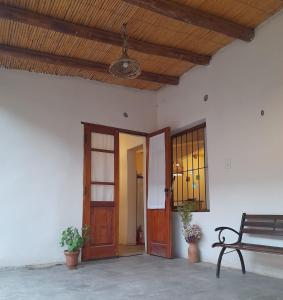 a porch with a bench and a wooden ceiling at mirapampa in Maimará
