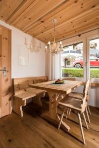 een eetkamer met een houten tafel en stoelen bij Unterkunft CASA LA RODA NR 5 URSIN in Sedrun