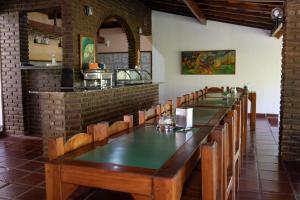 une salle à manger avec une grande table et des chaises dans l'établissement Pousada do Rio Corrente, à Santa Maria da Vitória