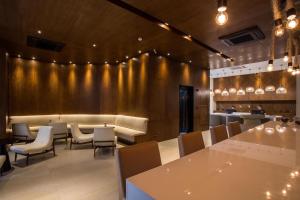 a restaurant with tables and chairs and a gold wall at Residencial Estanconfor com Vista Mar 2 AC e garagem in Santos +27 photos