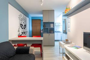 een woonkamer met een bank en een keuken bij Flat 1 Quarto Jaqueira Recife - Wi-fi e Garagem in Recife