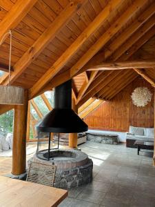 una sala de estar con chimenea y techo de madera. en Punta Manzano en Villa La Angostura