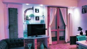 uma sala de estar com televisão e paredes cor-de-rosa em Athena soggiorno em San Piero a Sieve