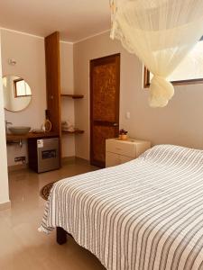 una camera con letto bianco e specchio di La Nómada Digital - Máncora Playa & Piscina a Máncora