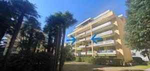 ein Gebäude mit blauen Pfeilen auf der Seite in der Unterkunft Apartment 10 Palmen Locarno in Locarno