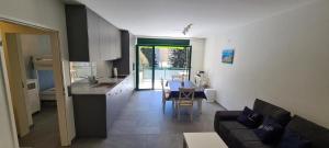 eine Küche und ein Wohnzimmer mit einem Sofa und einem Tisch in der Unterkunft Apartment 10 Palmen Locarno in Locarno