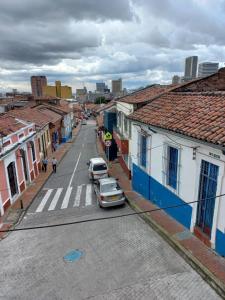 una calle de la ciudad con coches aparcados en la calle en MAMBE HOSTEL, en Bogotá