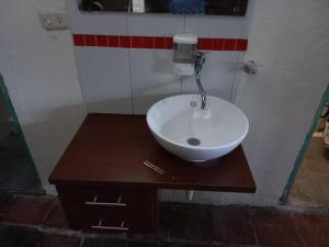 y baño con lavabo blanco sobre una mesa de madera. en MAMBE HOSTEL en Bogotá