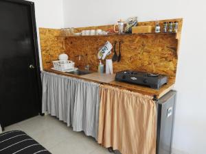 a kitchen counter with a sink and a stove at Casa del Mango, une pause entre deux aventures in Santa Marta